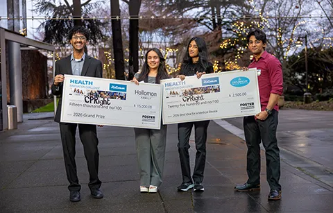 Four people holding up large checks.