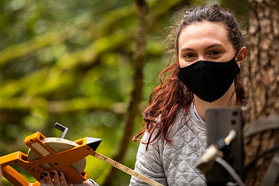 a student conducting research in a forest