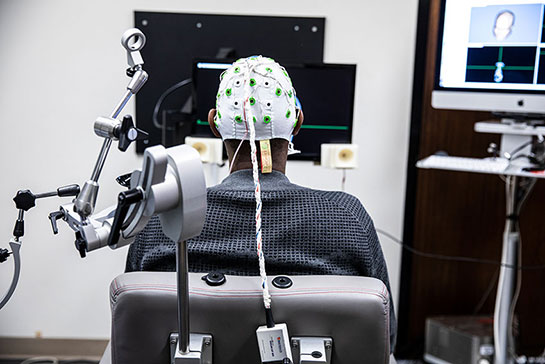 A person wearing an EEG cap sitting in a lab