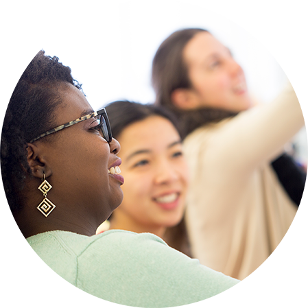 three students smiling and looking at a whiteboard