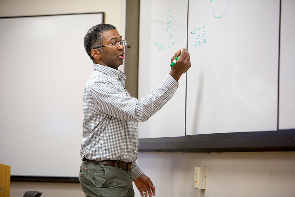instructor writing on a eboard
