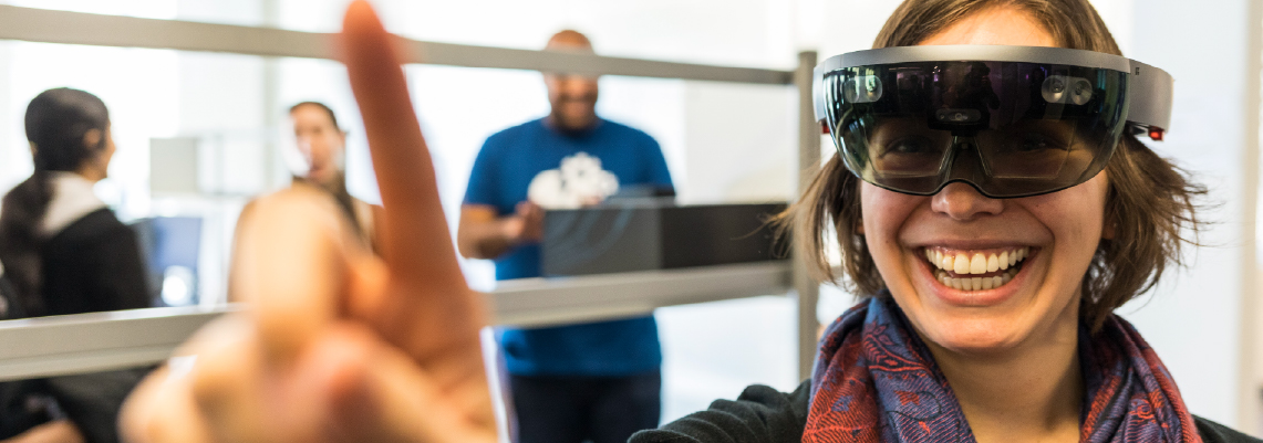 Woman wearing AR goggles and pointing at the camera