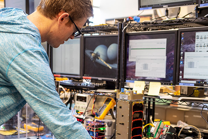 Student surrounded by screens working on prototype