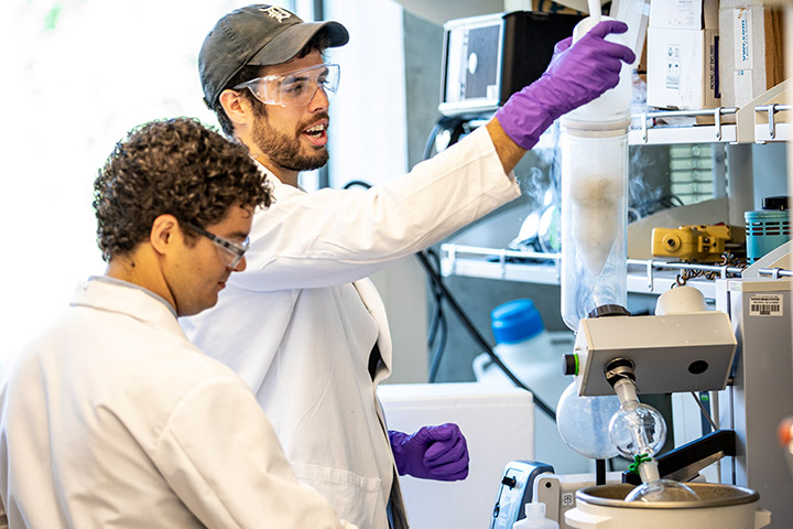 Students wearing lab coats working in lab