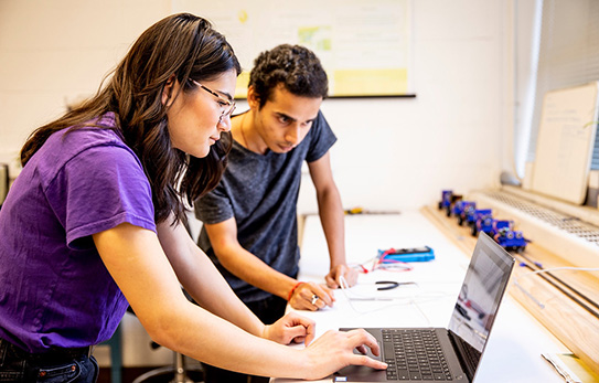 two students looking at a laptop