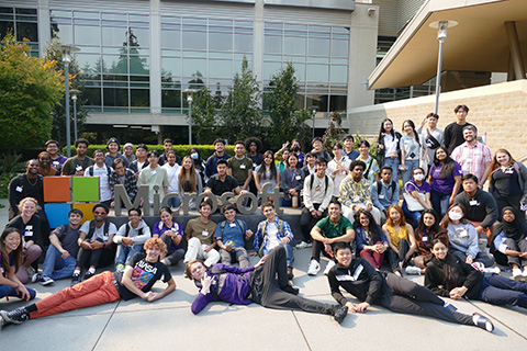 A group shot of students in front of a large Microsoft logo