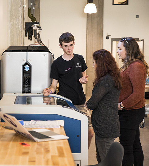 Student demonstrating MILL equipment for fellow students