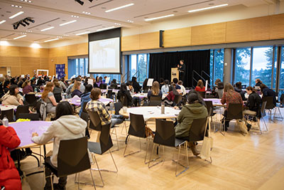 room with students sitting and a speaker at the podium