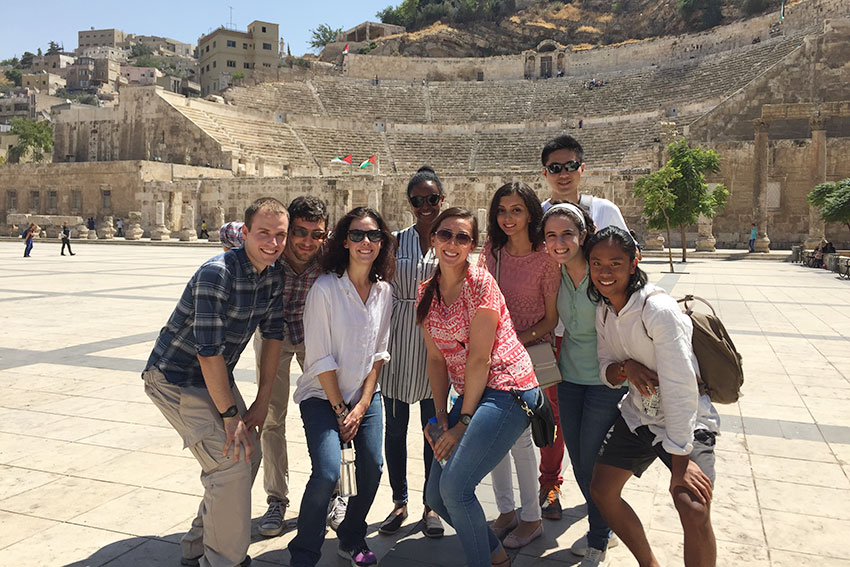 A group of students in front of an ancient Jordan structure
