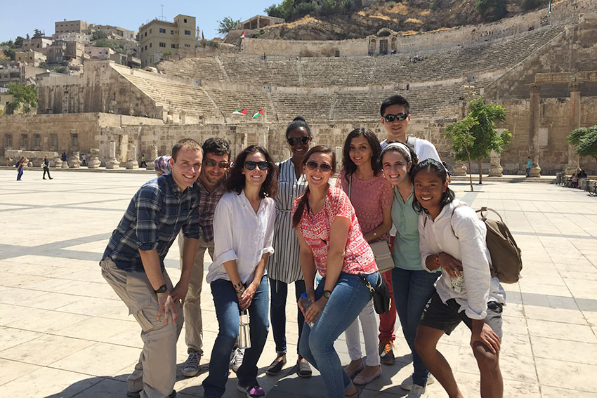 A group of students in front of an ancient Jordan structure