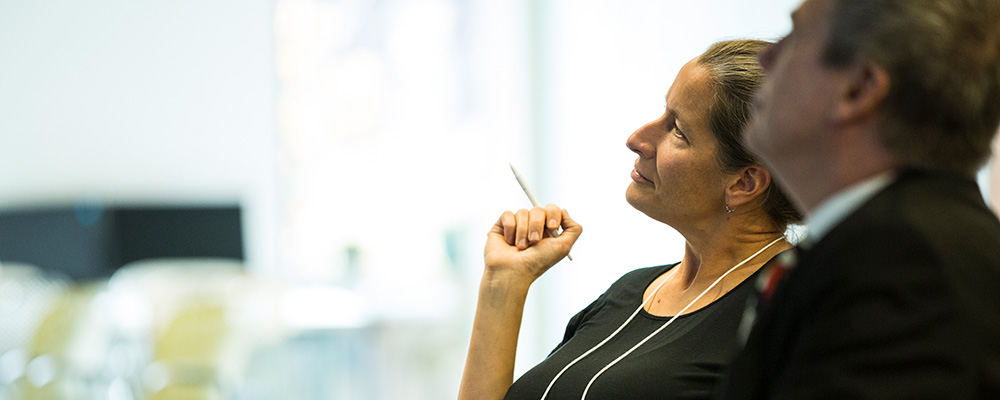 Two people listening and taking notes