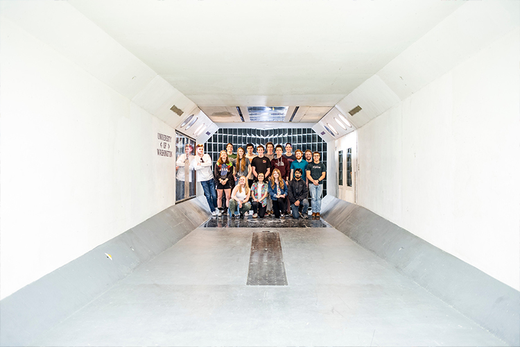 Second slide: Group of students posing together inside of the Kirsten Wind Tunnel