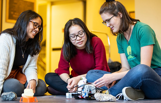 group of students analyzing a circuit board