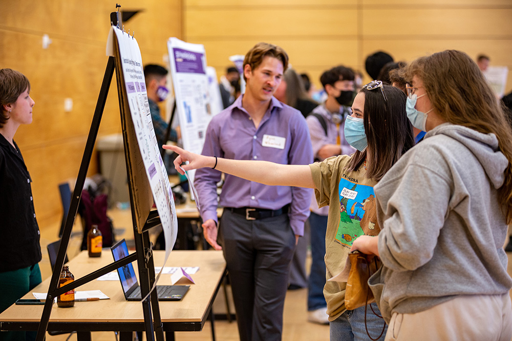 two people looking at a poster at a Capstone showcase