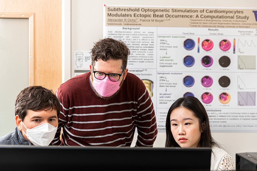 Boyle and two researchers looking at a computer monitor