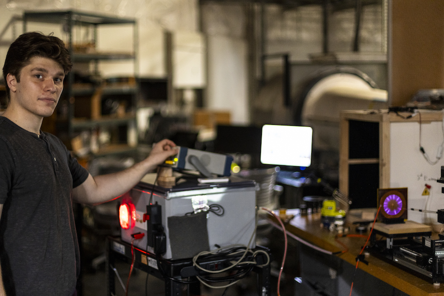 A person in a lab adjusting a device and looking at the camera