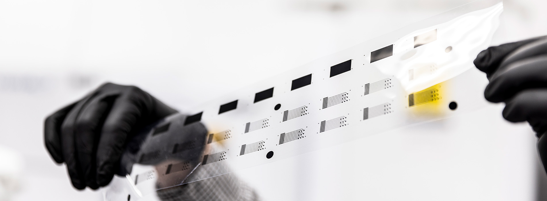 A hand in black glove holding a strip of film