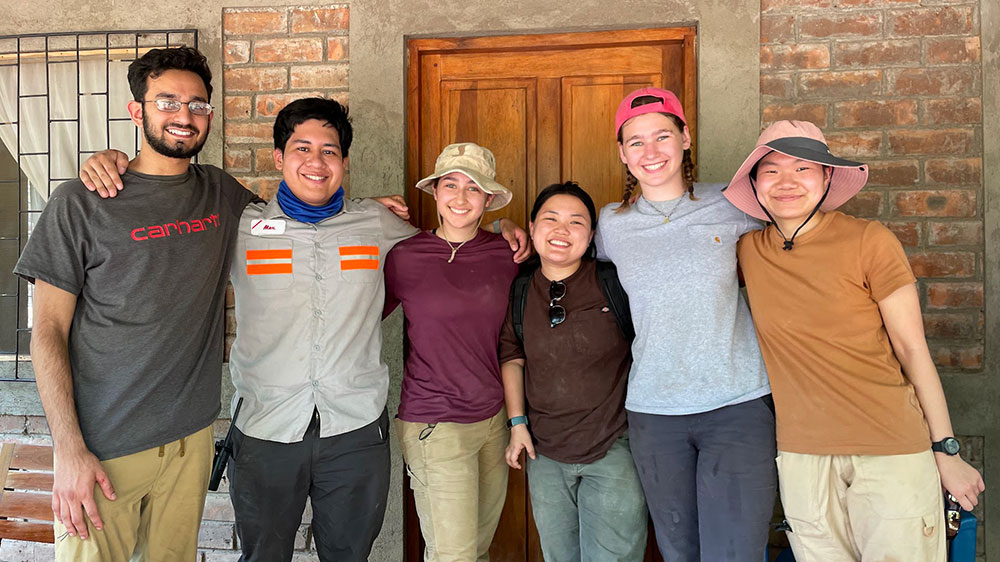 The EWB students standing side-by-side in front of a house