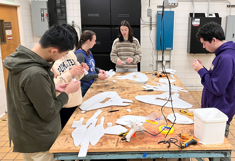 A group of students assembling aircrafts