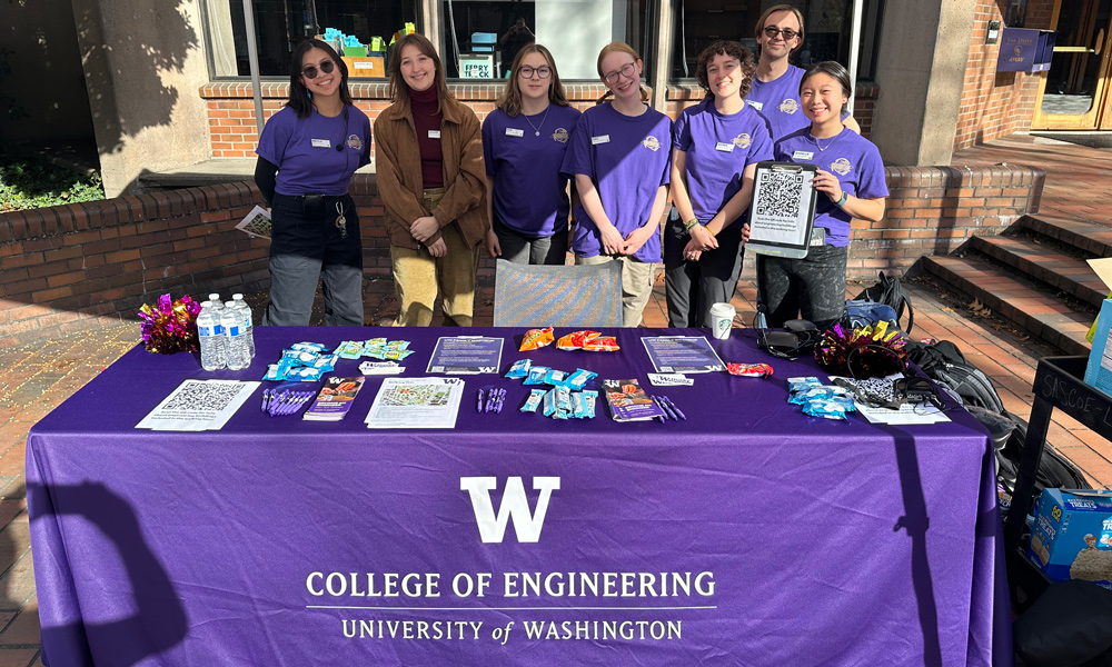 Engineering Ambassadors posing at a table where they answered questions and provided information to prospective students.