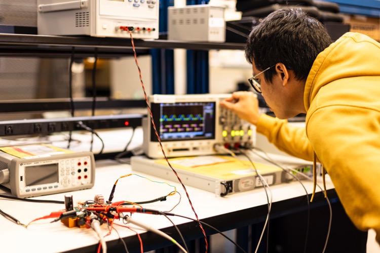 A student analyzing a cicuit board's data on a screen