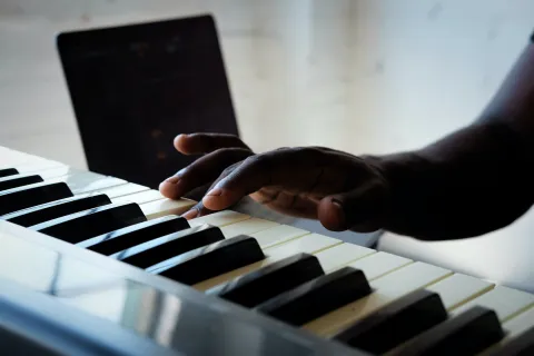 A hand pressing a piano key