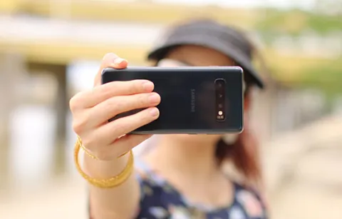 woman holding in a smartphone in front of her face