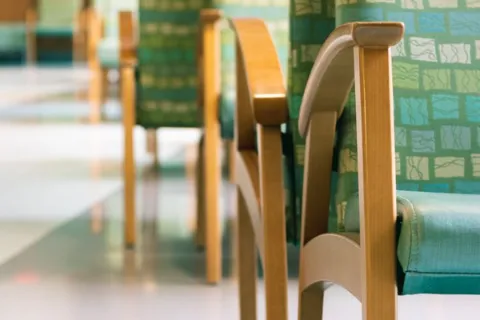 A row of green chairs in a waiting room