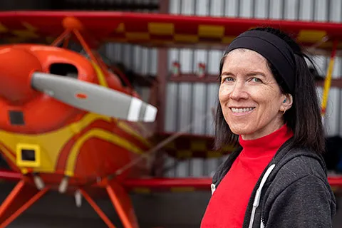 Professor Cecilia Aragon standing in front of an airplane