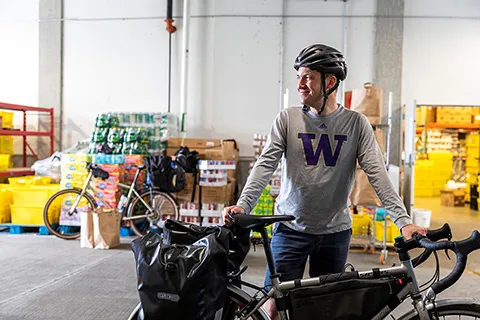 CEE Ph.D. student Dan McCabe standing next to a bike inside of a food bank