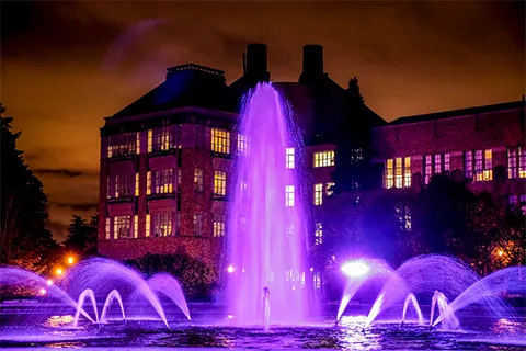 Purple water fountain with UW building in the background
