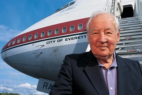 A close-up of Boeing 747 creator, Joe Sutter standing in front of a plane.
