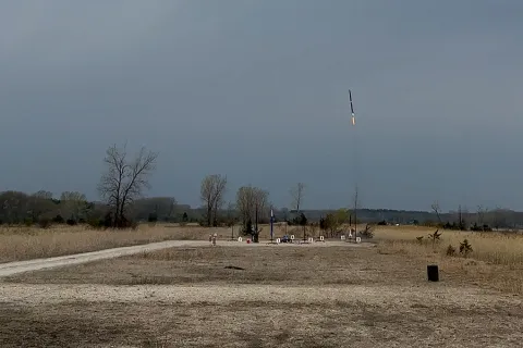 Open field where a small rocket is being launched