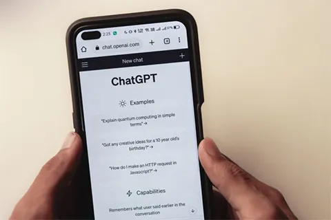 A hand holding a phone that has ChatGPT on the screen