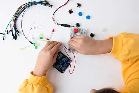 child's hands adjusting a circuit board