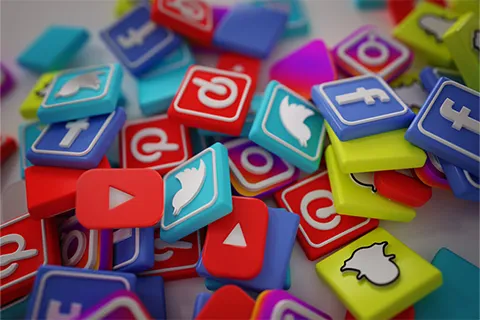 Pile of colorful 3-D printed tiles with social media platform logos, including Facebook, Twitter, Pinterest, Instagram, YouTube and Snapchat