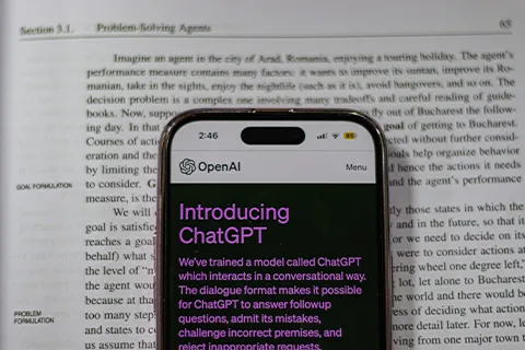 Close up of a smart phone on top of a book with the ChatGPT app opened on the screen