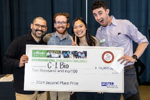 The UW C-1 Bio team holding a massive check commemorating their second place prize
