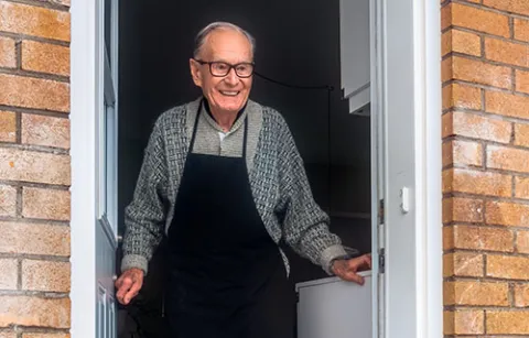elderly man standing in a doorway