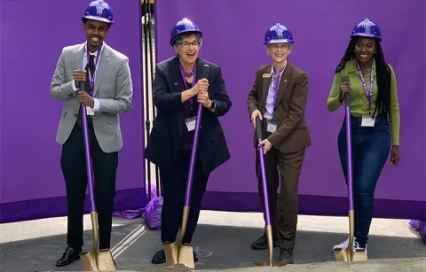 Four people with purple hard hats and groundbreaking shovels at the UW Interdisciplinary Engineering Building