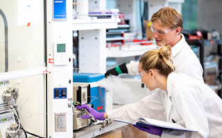 Students wearing lab coats in lab setting